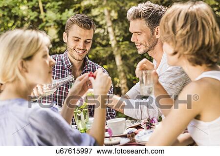Stock Photo - Group of friends enjoying garden party. Fotosearch