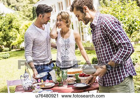 Group of friends setting up garden party View Large Photo Image Stock Image - Group of friends setting up garden party. Fotosearch