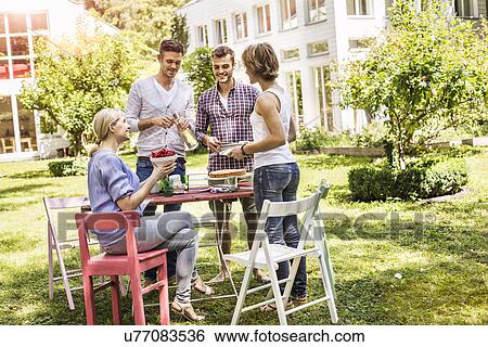 Group of friends setting up garden party View Large Photo Image Stock Photograph - Group of friends setting up garden party. Fotosearch