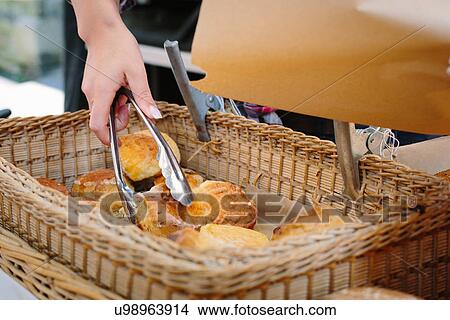 Hand picking up scone with tongs View Large Photo Image Picture - Hand picking up scone with tongs. Fotosearch