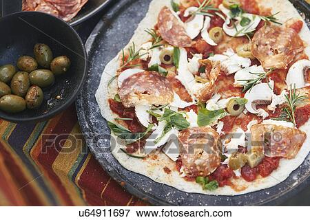 Homemade uncooked pizza on garden table View Large Photo Image Stock Photo - Homemade uncooked pizza on garden table. Fotosearch