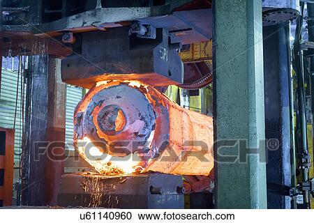 Stock Image - Hot steel in forging press in steelworks. Fotosearch