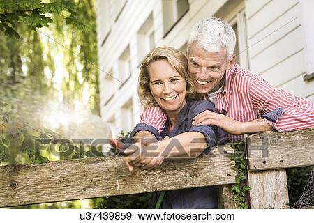 Husband and wife playing with hosepipe in garden View Large Photo Image Stock Photo - Husband and wife playing with hosepipe in garden. Fotosearch