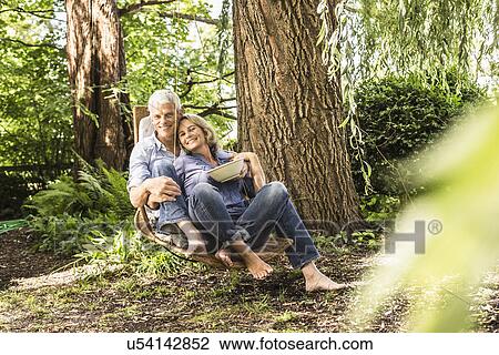 Husband and wife relaxing with bowl of cherries on hammock View Large Photo Image Stock Image - Husband and wife relaxing with bowl of cherries on hammock. Fotosearch