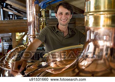 Stock Image - Male brewer working in brewhouse. Fotosearch