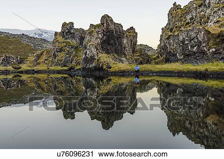 "Male hiker crouching by lake and rock formations, Snaefellsnes peninsula, Djupalonssandur, Iceland" View Large Photo Image Stock Image - "Male hiker crouching by lake and rock formations, Snaefellsnes peninsula, Djupalonssandur, Iceland". Fotosearch