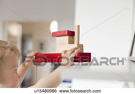 Male toddler playing with toy boat in nursery View Large Photo Image Stock Photograph - Male toddler playing with toy boat in nursery. Fotosearch