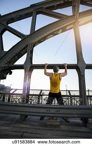 "Man doing chin-ups on bridge, Munich, Bavaria, Germany" View Large Photo Image Picture - "Man doing chin-ups on bridge, Munich, Bavaria, Germany". Fotosearch
