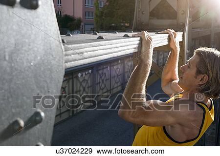 "Man doing chin ups on bridge, Munich, Bavaria, Germany" View Large Photo Image Stock Photo - "Man doing chin ups on bridge, Munich, Bavaria, Germany". Fotosearch
