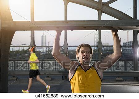 "Man doing chin-ups on bridge, Munich, Bavaria, Germany" View Large Photo Image Stock Photo - "Man doing chin-ups on bridge, Munich, Bavaria, Germany". Fotosearch