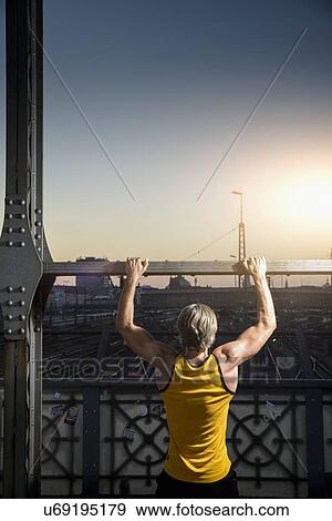 "Man doing chin-ups on bridge, Munich, Bavaria, Germany" View Large Photo Image Stock Photo - "Man doing chin-ups on bridge, Munich, Bavaria, Germany". Fotosearch