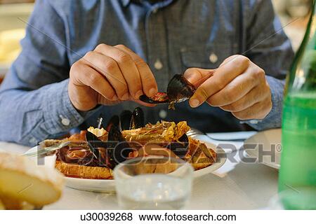 Man eating mussel with hands View Large Photo Image Stock Photo - Man eating mussel with hands. Fotosearch