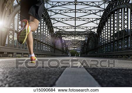 "Man jogging on bridge, Munich, Bavaria, Germany" View Large Photo Image Picture - "Man jogging on bridge, Munich, Bavaria, Germany". Fotosearch