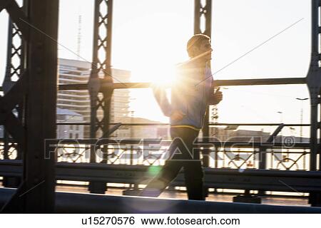 Stock Photograph - "Man jogging on bridge, Munich, Bavaria, Germany". Fotosearch