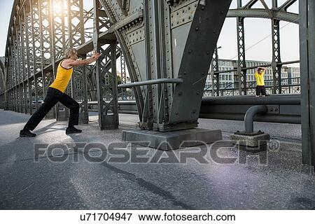 Stock Photo - "Man stretching on bridge, Munich, Bavaria, Germany". Fotosearch