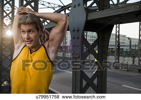 Stock Photo - "Man stretching on bridge, Munich, Bavaria, Germany". Fotosearch