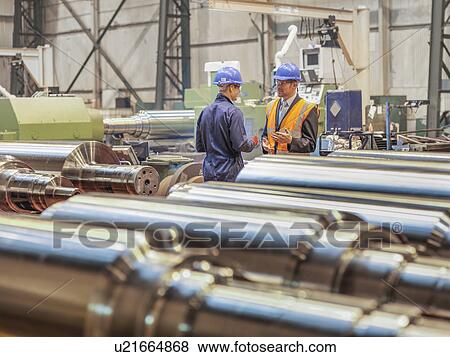 Manager and worker in discussion in engineering factory View Large Photo Image Stock Photo - Manager and worker in discussion in engineering factory. Fotosearch