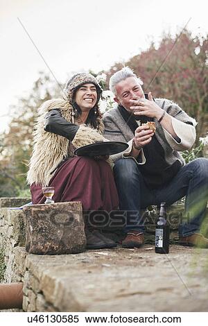 Mature hippy couple eating homemade pizza on garden wall View Large Photo Image Stock Photography - Mature hippy couple eating homemade pizza on garden wall. Fotosearch