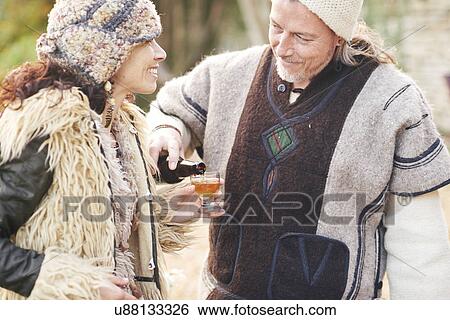 Mature hippy couple pouring glass of cider in garden View Large Photo Image Stock Photograph - Mature hippy couple pouring glass of cider in garden. Fotosearch