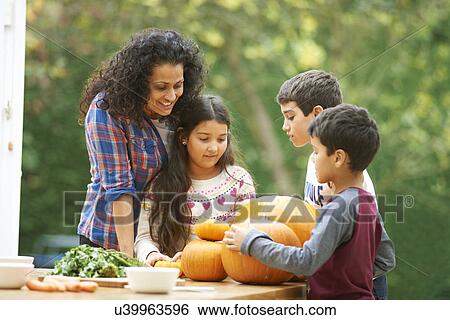 Mature mother and three children admiring homegrown pumpkins in kitchen View Large Photo Image Stock Photograph - Mature mother and three children admiring homegrown pumpkins in kitchen. Fotosearch