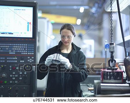 Mid adult female engineer inspecting part in factory View Large Photo Image Stock Image - Mid adult female engineer inspecting part in factory. Fotosearch