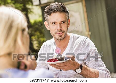 "Mid adult man in garden, holding plate with cake on" View Large Photo Image Stock Photo - "Mid adult man in garden, holding plate with cake on". Fotosearch