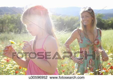 "Mid adult woman and daughter picking wildflowers in meadow, Majorca, Spain" View Large Photo Image Stock Image - "Mid adult woman and daughter picking wildflowers in meadow, Majorca, Spain". Fotosearch