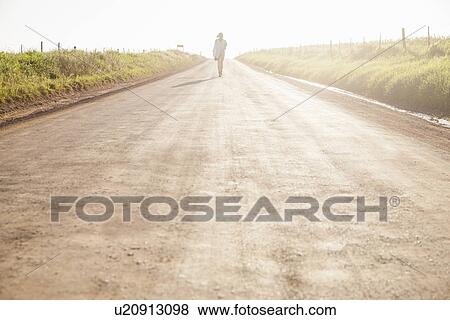 "Mid adult woman walking on country road, rear view" View Large Photo Image Stock Photo - "Mid adult woman walking on country road, rear view". Fotosearch