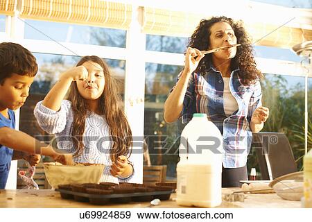 Mother and children tasting cake mixture in kitchen View Large Photo Image Stock Photo - Mother and children tasting cake mixture in kitchen. Fotosearch