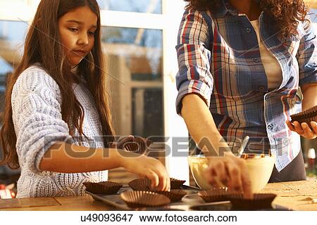Stock Photo - Mother and daughter baking in kitchen. Fotosearch