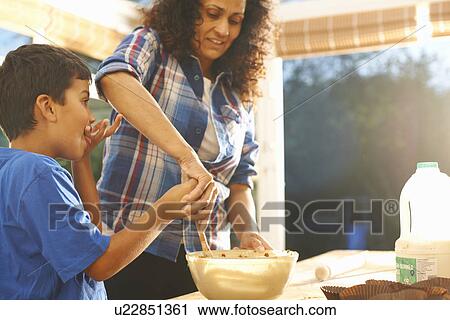 Stock Image - Mother and son baking in kitchen. Fotosearch