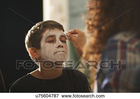 Mother painting sons face white for halloween View Large Photo Image Stock Photo - Mother painting sons face white for halloween. Fotosearch