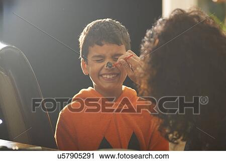 Mother painting sons pumpkin nose for halloween View Large Photo Image Stock Image - Mother painting sons pumpkin nose for halloween. Fotosearch