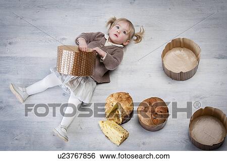 Overhead portrait of female toddler lying on floor holding pannetone cake case View Large Photo Image Stock Photograph - Overhead portrait of female toddler lying on floor holding pannetone cake case. Fotosearch