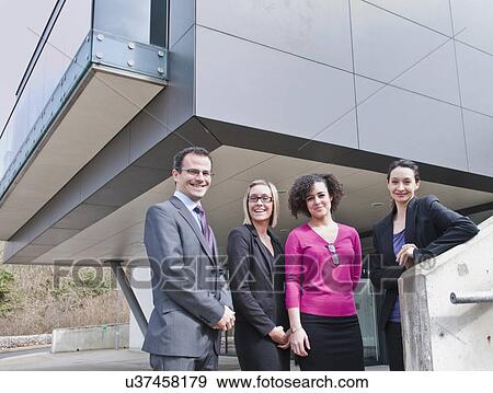 Stock Photo - Portrait of businessman and three businesswomen outside office building. Fotosearch