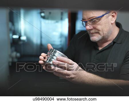 Portrait of engineer holding engineered part at CNC machine View Large Photo Image Picture - Portrait of engineer holding engineered part at CNC machine. Fotosearch