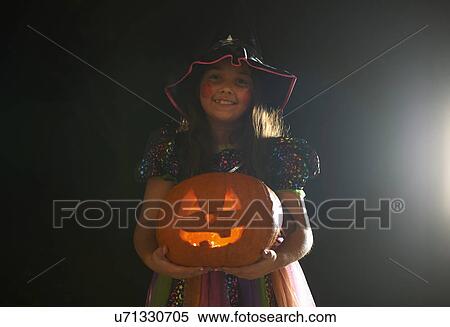 Portrait of girl wearing halloween witch costume holding pumpkin View Large Photo Image Stock Photography - Portrait of girl wearing halloween witch costume holding pumpkin. Fotosearch