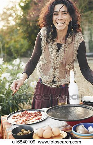 Portrait of mature hippy female preparing pizza in garden View Large Photo Image Stock Photo - Portrait of mature hippy female preparing pizza in garden. Fotosearch