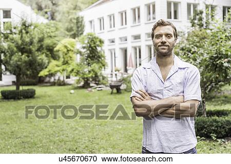 Portrait of mid adult man in front of house View Large Photo Image Stock Image - Portrait of mid adult man in front of house. Fotosearch