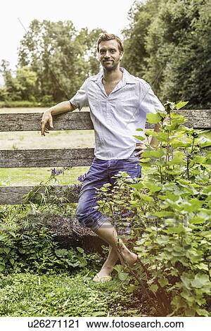 Portrait of mid adult man leaning against garden fence View Large Photo Image Stock Image - Portrait of mid adult man leaning against garden fence. Fotosearch