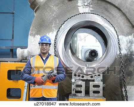 Stock Photo - Portrait of steelworker with cutting tool in engineering factory. Fotosearch