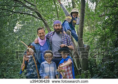 Stock Photo - Portrait of two adult men and four boys dressed up in forest. Fotosearch