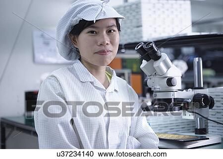 Stock Image - Portrait of worker in factory that specialises in creating functional circuits on flexible surfaces. Fotosearch