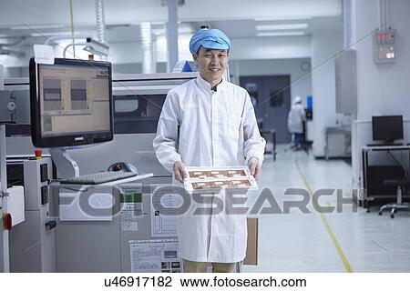 Stock Image - Portrait of worker in factory that specialises in creating functional circuits on flexible surfaces. Fotosearch