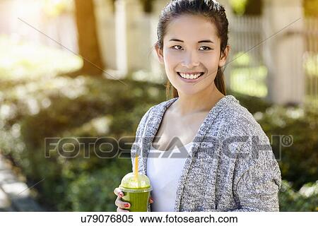Portrait of young woman drinking takeaway coffee View Large Photo Image Stock Photography - Portrait of young woman drinking takeaway coffee. Fotosearch