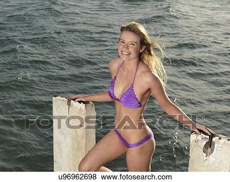 Stock Photo - "Portrait of young woman on pier wearing bikini, Altona, Melbourne, Victoria, Australia". Fotosearch