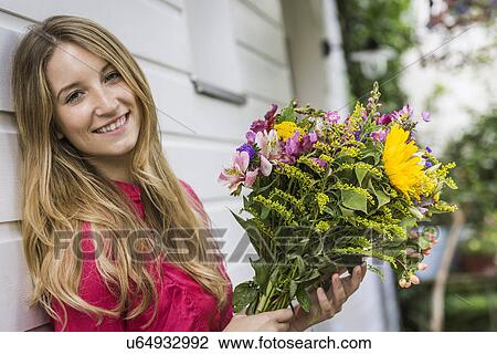 Portrait of young woman with bunch of flowers View Large Photo Image Stock Image - Portrait of young woman with bunch of flowers. Fotosearch