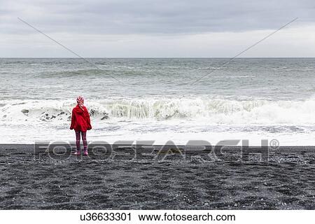 Stock Image - "Rear view of girl on black beach, Hvalnes, Iceland, ". Fotosearch