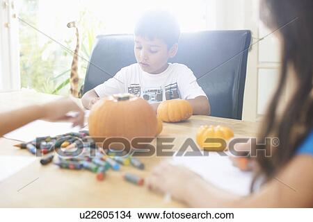 Siblings drawing at dining table View Large Photo Image Picture - Siblings drawing at dining table. Fotosearch