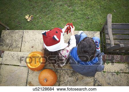 Siblings sitting on steps in garden View Large Photo Image Picture - Siblings sitting on steps in garden. Fotosearch